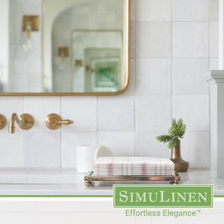 Image of rose gold geometric design guest towels with a bathroom sink in the background.