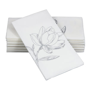 Image of SimuLinen silver magnolia guest towels. These are a white disposable guest towel with a silver-colored outline of a magnolia flower.