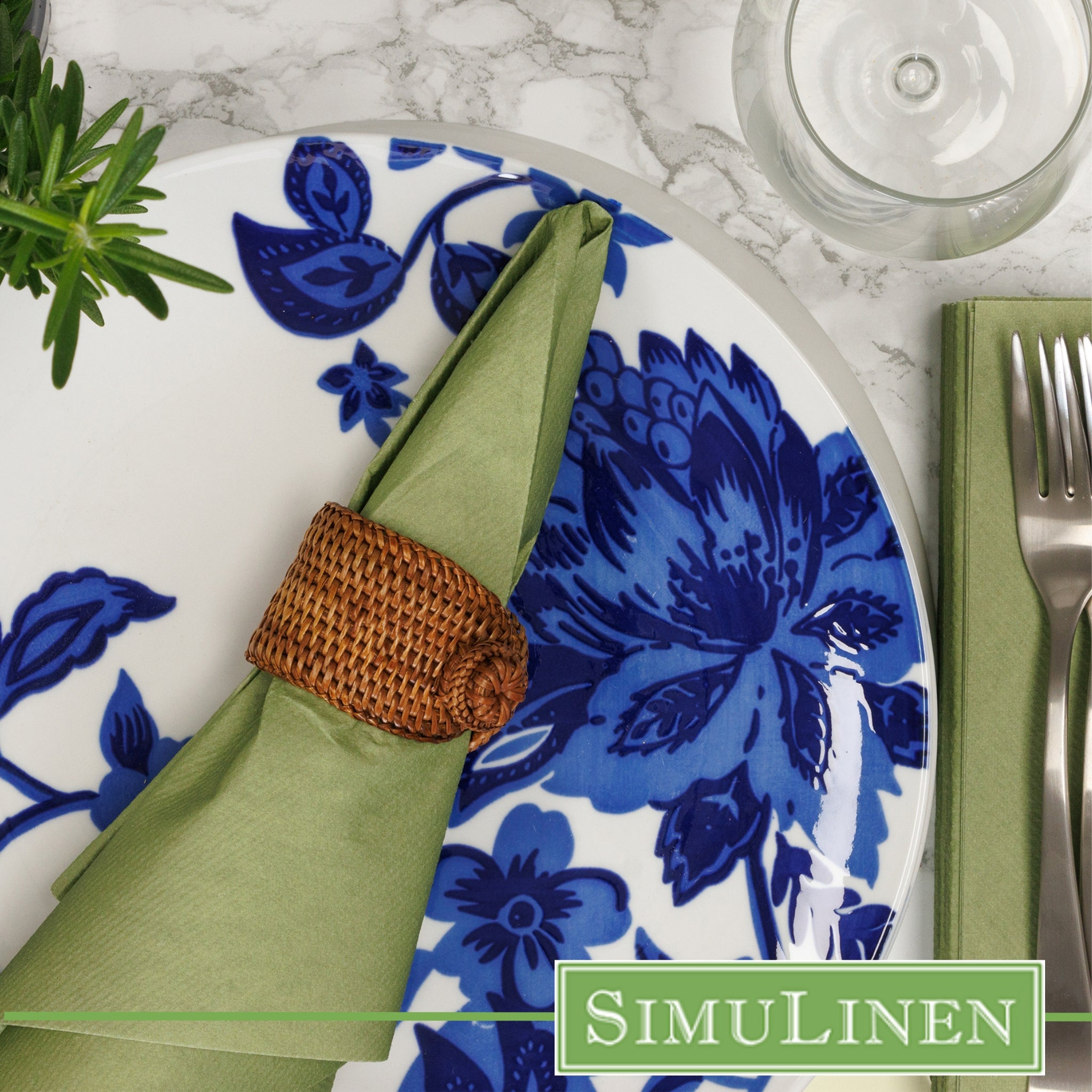 Olive green SimuLinen dinner napkin in napkin ring on blue floral plate