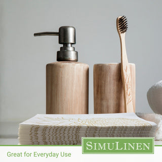 Image of gold pineapple guest towels with a soap dispenser and toothbrush in the background.