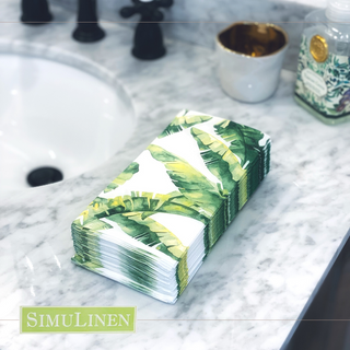 Image of Banana Leaf guest towels on a marbled bathroom sink.