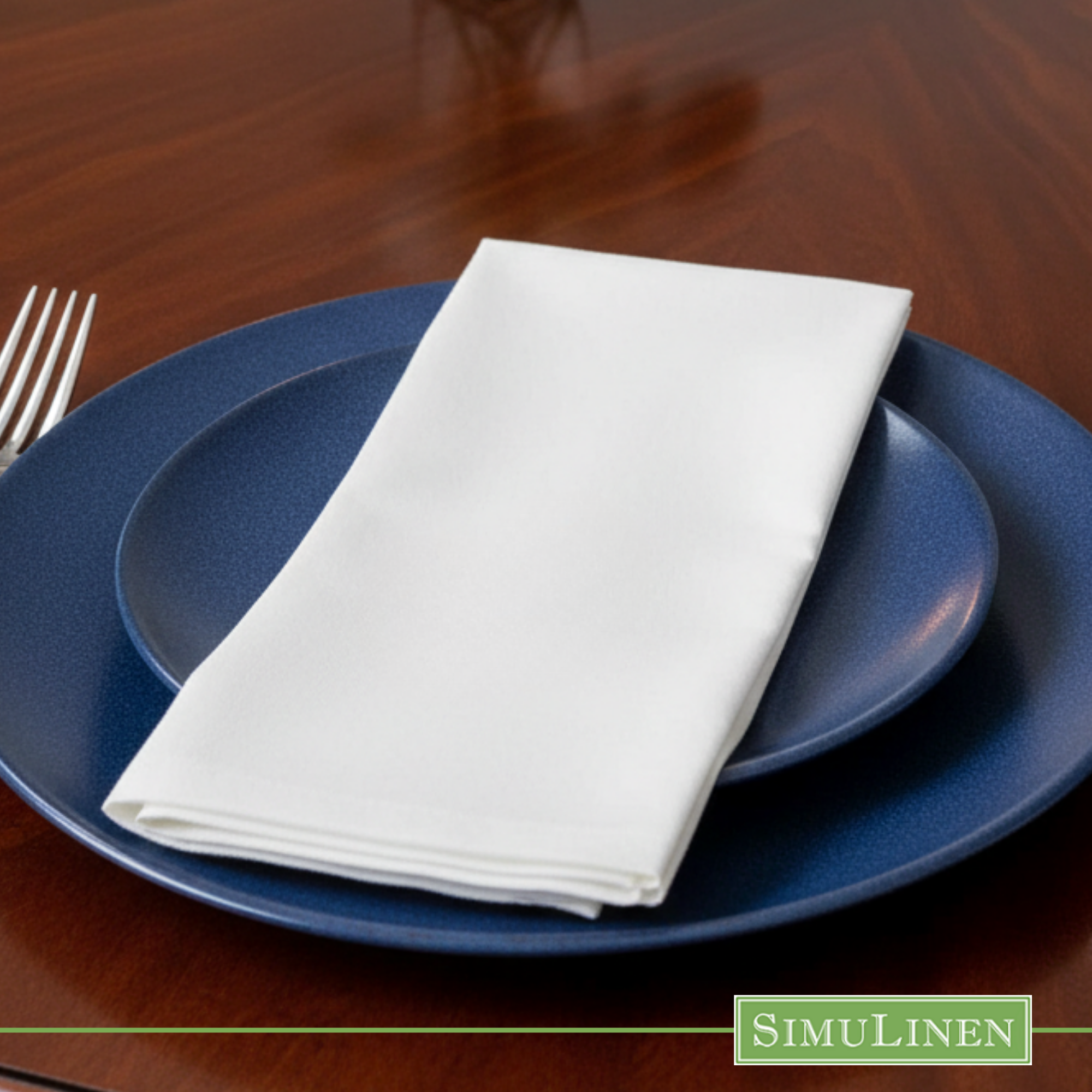 White SimuLinen dinner napkin on blue plate