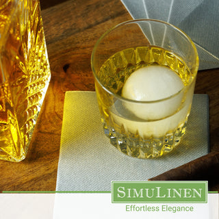 SimuLinen Silver cocktail napkins with a glass of whiskey on top.