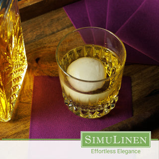SimuLinen aubergine beverage napkin underneath a whiskey glass.