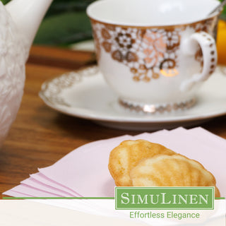 Light pink beverage napkins with a fancy tea cup in the background.