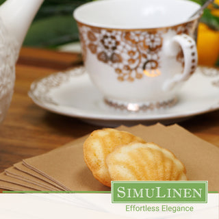 Natural brown beverage napkins with a fancy tea cup in the background.