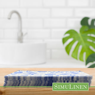 Image of blue nautical guest towels on a wooden board with a bathroom sink in the background.