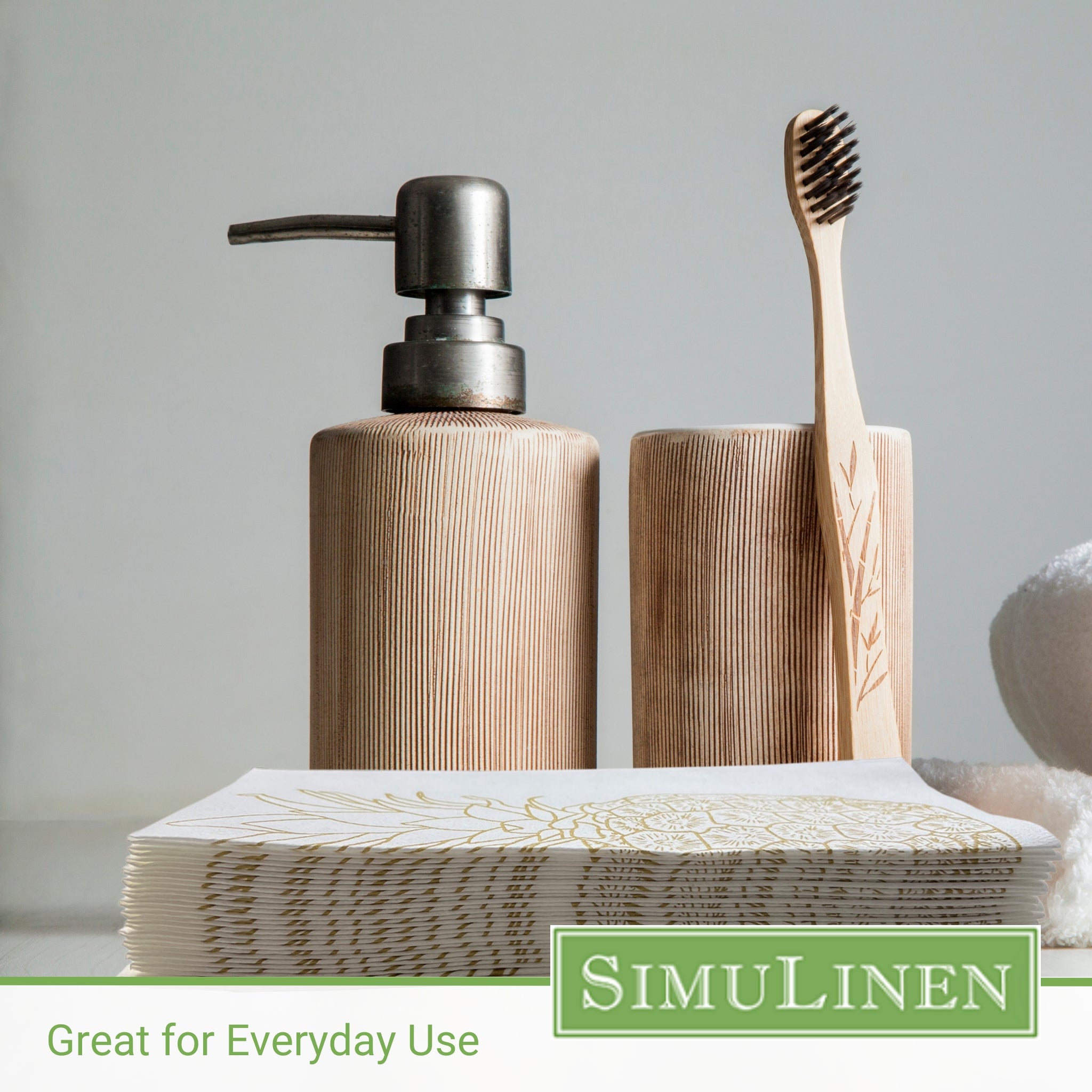 Image of gold pineapple guest towels with a soap dispenser and toothbrush in the background.