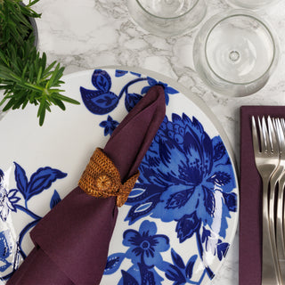 Plum dinner napkin on blue floral plate on marble countertop