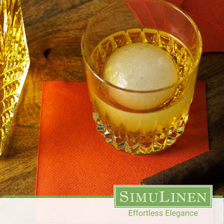 SimuLinen terracotta beverage napkins with a glass of whiskey on top.