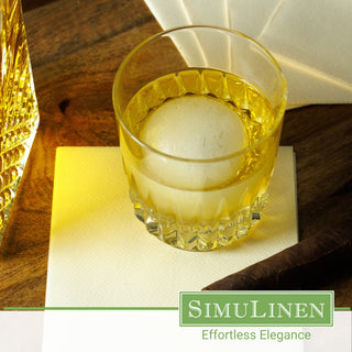 SimuLinen champagne beverage napkins underneath a whiskey glass.