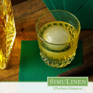 SimuLinen dark green disposable beverage napkins with a whiskey glass on top.