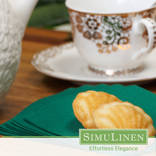 SimuLinen dark green disposable cocktail napkins with a fancy tea cup behind them.