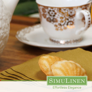 SimuLinen gold beverage napkins with a fancy tea cup in the background.