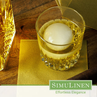 SimuLinen gold beverage napkins underneath a whiskey glass.