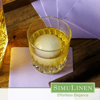 SimuLinen lavender cocktail napkins with a whiskey glass on top.