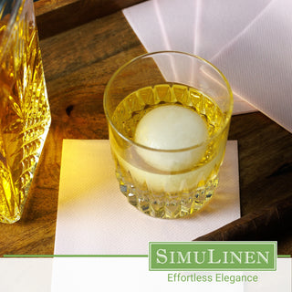 SimuLinen light pink beverage napkin with a glass of whiskey on top.