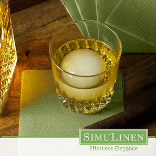 Olive green disposable luxury paper napkins with a whiskey glass on top.